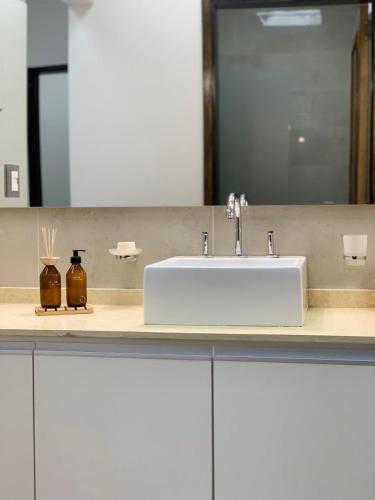 Un mostrador de baño con un lavabo y un espejo. en Laprida Suites 1 San Juan, en San Juan