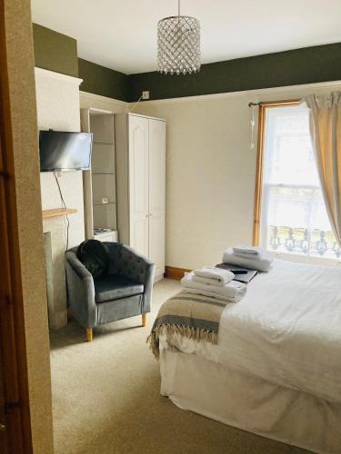 a bedroom with a bed and a chair and a window at The Pathway Guesthouse in Whitby