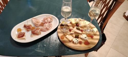 a table with two plates of food and wine glasses at Casa Matilde Home Restaurant Hotel in Curiglia