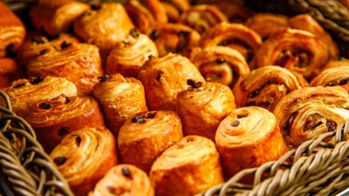 a bunch of pastries are in a basket at Crowne Plaza Manchester Airport by IHG in Hale