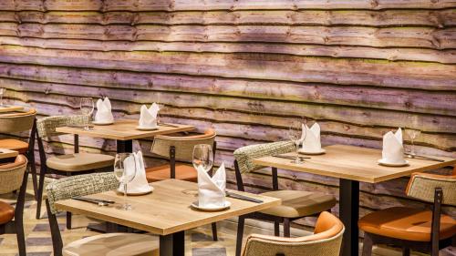 a row of tables and chairs in a restaurant at Crowne Plaza Manchester Airport by IHG in Hale