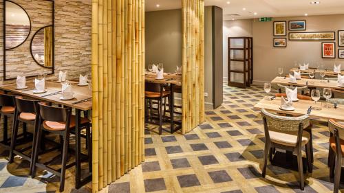 a dining room with wooden tables and chairs at Crowne Plaza Manchester Airport by IHG in Hale