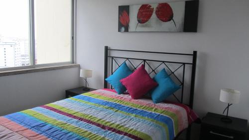 ポルティマンにあるTarik Apartmentのベッドルーム1室(カラフルな枕付きのベッド1台付)
