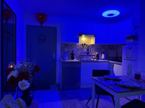 a blue kitchen with a table and a dining room at Suite Eden Spa, Appart'hôtel bien être , Patio de standing barbecue - TV XL CinéSport, Lit Q-Size, Wifi, P-Gratuit en Résidence in Avion