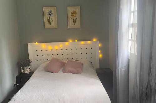 a bedroom with a white bed with lights on it at Pousada Casa Florinda in Teresópolis