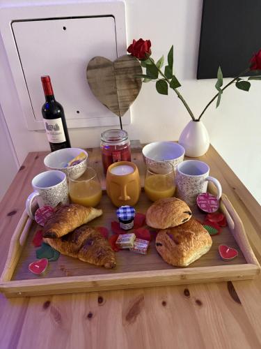 een dienblad met brood en een fles wijn bij Suite Eden Spa, Appart'hôtel bien être , Patio de standing barbecue - TV XL CinéSport, Lit Q-Size, Wifi, P-Gratuit en Résidence in Avion