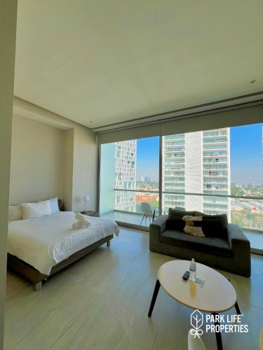 a bedroom with a bed and a couch and a table at Park Life Guadalajara in Guadalajara