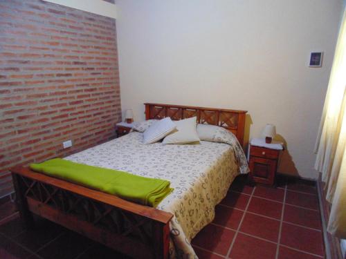 a bedroom with a bed and a brick wall at Cabañas los amigos Tala in Potrero de Garay