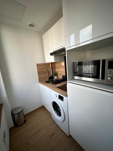 une cuisine avec un lave-linge et un micro-ondes dans l'établissement Studio en plein cœur de Nice, à Nice