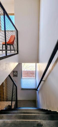 a staircase with a red chair in a building at Chic Townhome Retreat nestled Downtown in Albuquerque