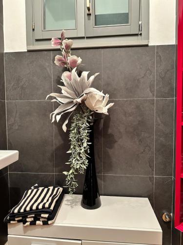 a vase with flowers on a counter in a bathroom at a casa di Emma in Grosseto