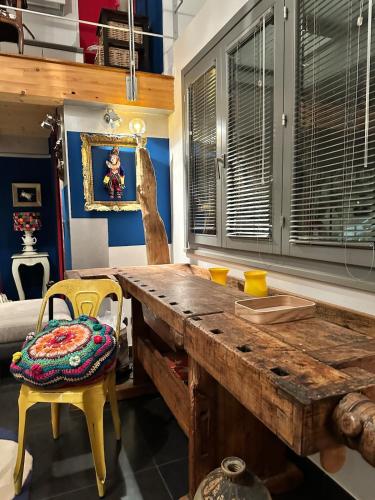 a kitchen with a wooden table and a yellow chair at a casa di Emma in Grosseto