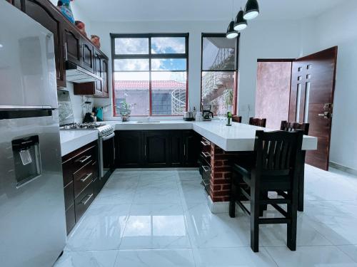 a large kitchen with a counter and a chair in it at Casa Franlus apartamento 1 planta baja in San Cristóbal de Las Casas