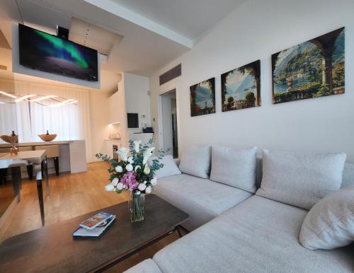 a living room with a couch and a table with flowers at Borgo Vico Luxury Suites in Como
