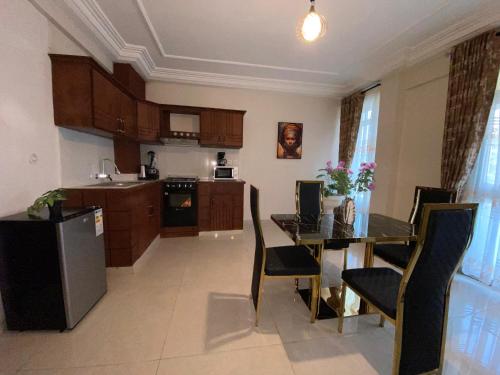 a kitchen with a table and a dining room at Résidence hôtelière MEDOM Palace, Bastos in Yaoundé