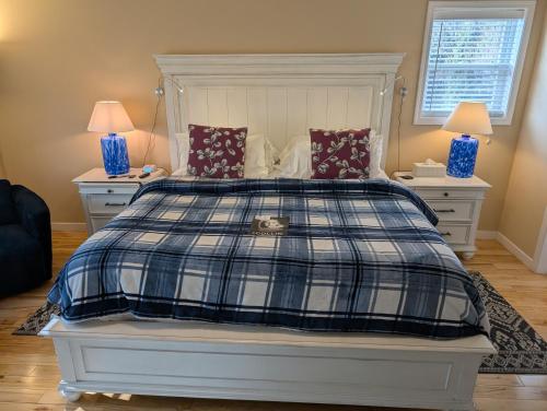 a bedroom with a bed with a blue and white plaid blanket at Salish B&B and Spa in West Kelowna