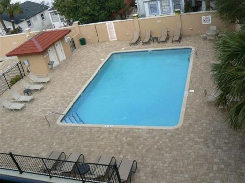 a large blue swimming pool with chairs around it at Brass Rail 319-Premier Condo on Tybee Island-Sleeps 10-2 Pools & Spa in Tybee Island