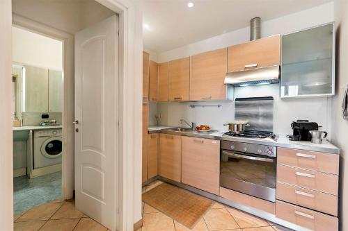 a kitchen with wooden cabinets and stainless steel appliances at Domus 21 Near Alassio Beach - Happy Rentals in Alassio