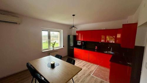 a kitchen with red cabinets and a table with chairs at Gorgeous nook in Góry Wysokie