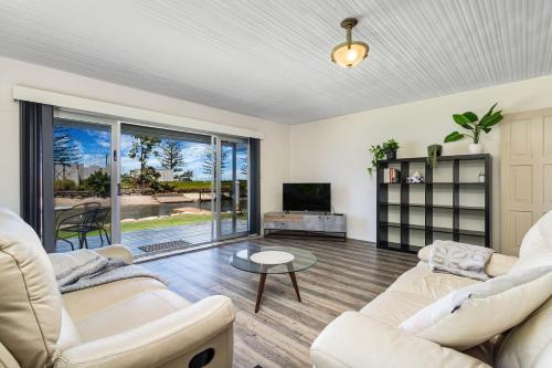 a living room with two white couches and a tv at Canal Luxury Living & Boat Ramp in Gold Coast