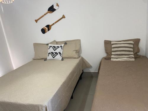 two beds sitting next to each other in a bedroom at Suites Frente ao Mar in Prado