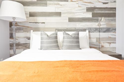 a bedroom with a white bed with pillows at La TUMU in Toronto
