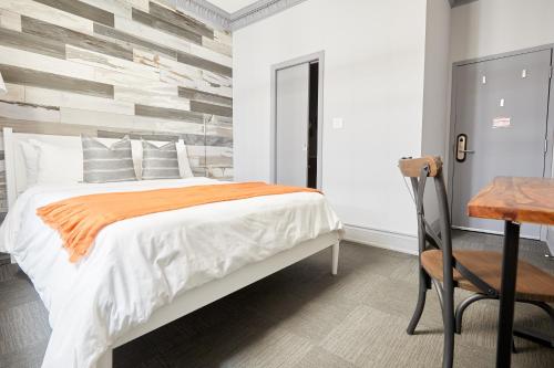 a bedroom with a bed and a desk and a chair at La TUMU in Toronto