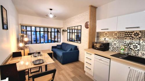 Il comprend une cuisine et un salon doté d'un canapé bleu. dans l'établissement L'Atelier du Fer, à Nevers