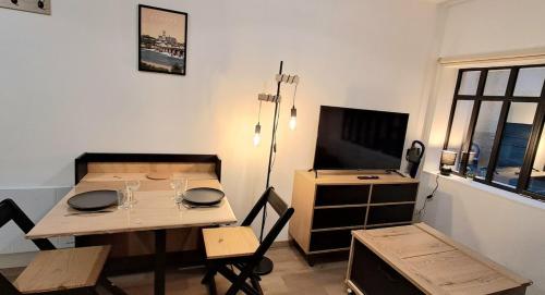 une salle à manger avec une table et une télévision dans l'établissement L'Atelier du Fer, à Nevers