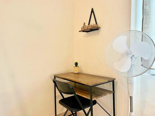 a desk with a chair and a fan in a room at Creux de l'Église - 2 Appartements cosy, 2 Salles de Bains, 8 personnes in Saint-Chamas