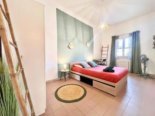 a bedroom with a red bed with a red blanket at Creux de l'Église - 2 Appartements cosy, 2 Salles de Bains, 8 personnes in Saint-Chamas
