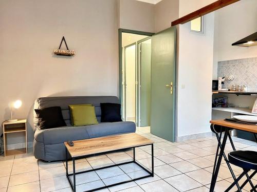 a living room with a blue couch and a table at Creux de l'Église - 2 Appartements cosy, 2 Salles de Bains, 8 personnes in Saint-Chamas