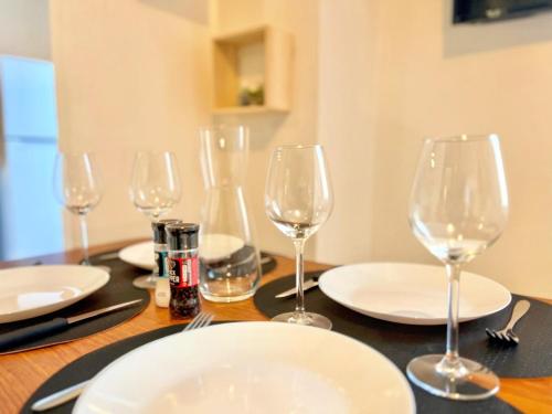 a table with wine glasses and plates on it at Creux de l'Église - 2 Appartements cosy, 2 Salles de Bains, 8 personnes in Saint-Chamas