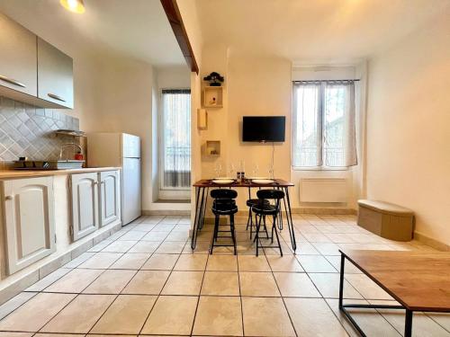 a kitchen with a table and chairs in a room at Creux de l'Église - 2 Appartements cosy, 2 Salles de Bains, 8 personnes in Saint-Chamas