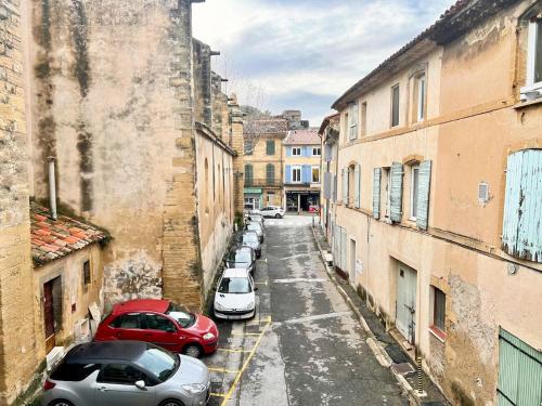 an alley with cars parked on the sides of buildings at Creux de l'Église - 2 Appartements cosy, 2 Salles de Bains, 8 personnes in Saint-Chamas