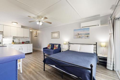 a bedroom with a bed and a kitchen at Sea La Vie in Edisto Island