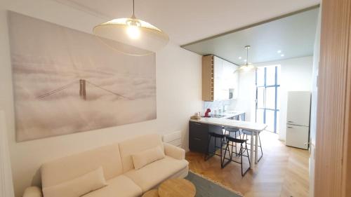 un salon avec un canapé et une cuisine dans l'établissement Appartement d'architecte au coeur de Bordeaux, à Bordeaux