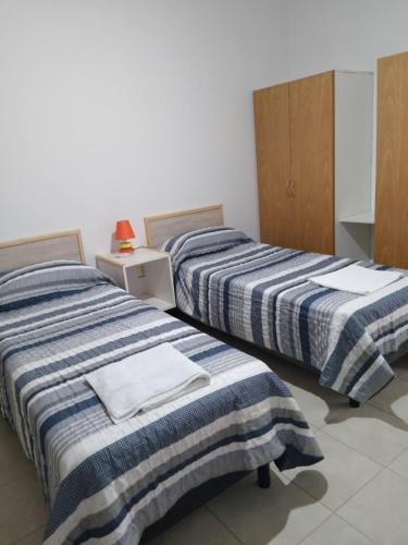 two beds sitting next to each other in a room at Hermoso triplex concordia in Concordia