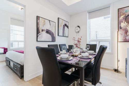 トロントにあるNew Elegant Suite for 8 w Patio - Heart of Torontoのダイニングルーム(テーブル、黒い椅子付)