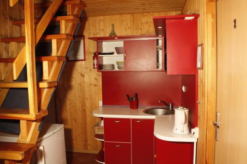 a small kitchen with red cabinets and a sink at The Jolly Man in Vilnius