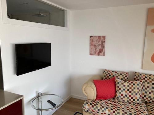 a living room with a couch and a flat screen tv at Janela do Minho in Caminha