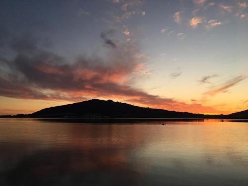 a sunset over a body of water with a mountain at Janela do Minho in Caminha