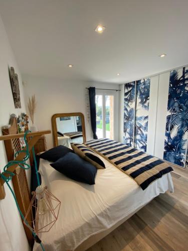 une chambre avec un grand lit et un miroir dans l'établissement Villa au grand chêne, à Saint-Raphaël
