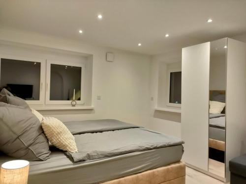 a bedroom with a bed and two windows at Modernes, stilvolles Apartment 5 in Memmingen