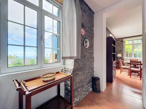 a living room with a table and windows at Quinta do Serrado in Porto Moniz