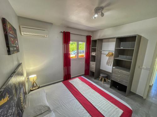 a bedroom with a bed and a red curtain at Guadeloupe Saint Francois 36 8 pax in Saint-François