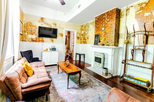 ein Wohnzimmer mit Couch und Kamin in der Unterkunft Ursulines Historic Creole Cottage (D) Steps to Qtr in New Orleans