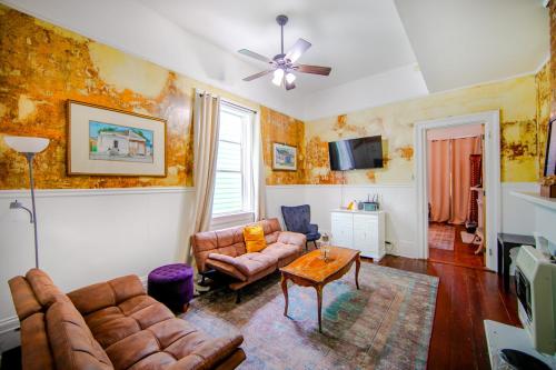 ein Wohnzimmer mit Sofa und Tisch in der Unterkunft Ursulines Historic Creole Cottage (D) Steps to Qtr in New Orleans