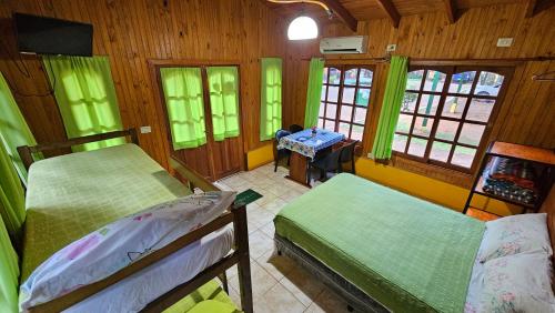 a bedroom with two beds and a desk in a room at Cabañas Rincon Santa Maria in Puerto Iguazú