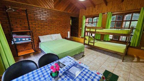a room with a bed and a table and chairs at Cabañas Rincon Santa Maria in Puerto Iguazú